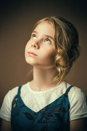 Portrait of a beautiful eight year old girl with calm pensive look. Childhood concept.の写真素材