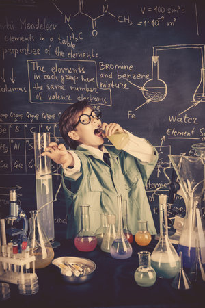 The boy scientist is going to drink the chemical solution he invented. Educational concept....