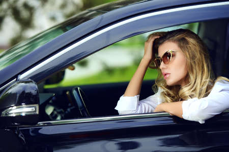 Portrait of a beautiful woman driving a car. Beauty, fashion. Outdoor summer portrait.の写真素材