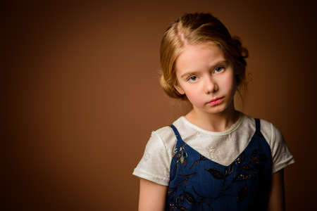 Portrait of a cute eight year old girl with sad calm look. Childhood concept.の写真素材