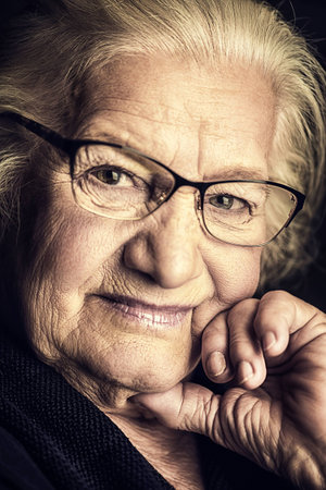 Portrait of a beautiful senior woman in elegant glasses smiling at camera.の写真素材