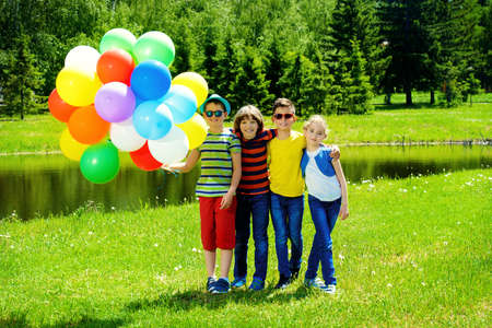 Group of cheerful children resting in the park. Outdoor activity. Summer holidays.の写真素材