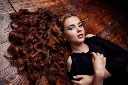 Beautiful girl with long curly hair. Beauty, fashion. Healthy hair, haircare cosmetics.の写真素材