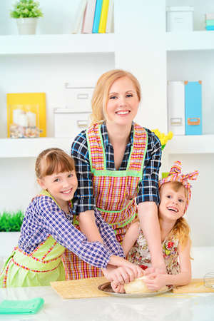 Loving family concept. Happy mother cooks with her daughters.の写真素材