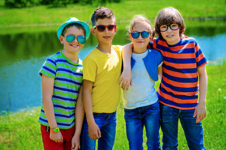 Group of cheerful children resting in the park. Outdoor activity. Summer holidays.の写真素材