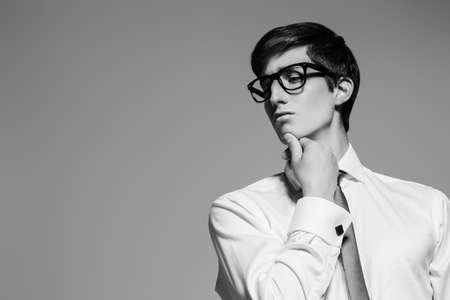 Black-and-white portrait of a handsome young man posing in white shirt and a tie. Business style. Studio fashion shot.の写真素材