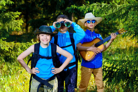 Three boys friends go hiking with backpacks. Summer holidays. Outdoor activities.の写真素材