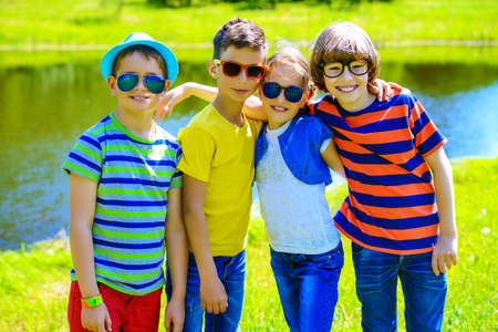 Group of cheerful children resting in the park. Outdoor activity. Summer holidays.の写真素材