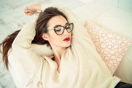 Beautiful sexy woman lying on a sofa at home. Beauty, fashion. Optics style.の写真素材