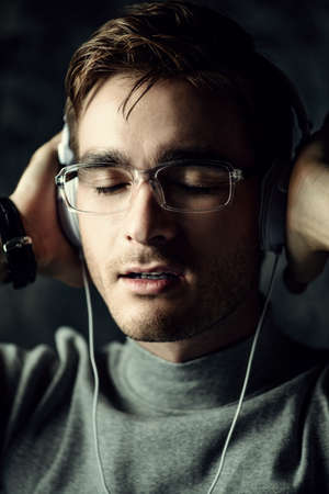 Handsome young man listenig to music in headphones.の写真素材