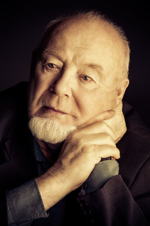 Portrait of old man over black background. Old age concept.