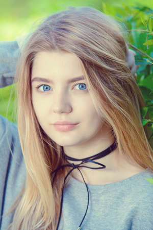 Portrait of a modern teen girl with long blonde hair posing outdoor. Beauty, fashion. Teen style.の写真素材