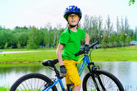 Cute happy boy is riding his bike. Happy summer holidays. Competition.の写真素材