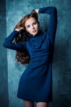 Fashion shot. Beautiful young model with long curly hair posing at studio. Hair, hairstyle.の写真素材