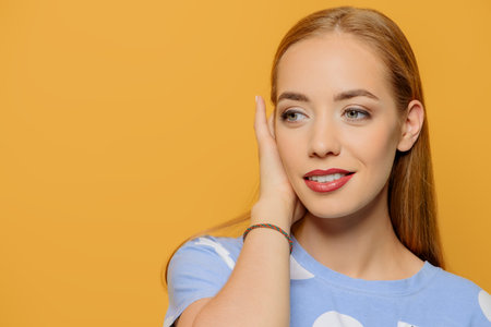 Joyful young woman with beautiful smile posing over yellow background. Happiness, summer concept. Copy space.の写真素材