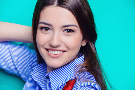 Portrait of a cheerful young woman with beautiful long hair over bright aquamarine background. Copy space. Beauty, haircare, skincare.の写真素材