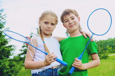 Two happy children play badminton. Summer outdoor activities.の写真素材