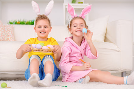 Easter holidays. Happy children painting eggs for Easter at home.