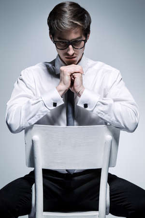 Portrait of a thoughtful young man posing in white shirt and a tie. Business style. Studio fashion shot.の写真素材