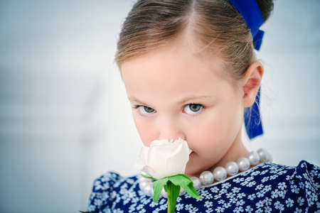 Close-up portrait of a beautiful little girl with elegant hairstyle. Kid's fashion.の写真素材