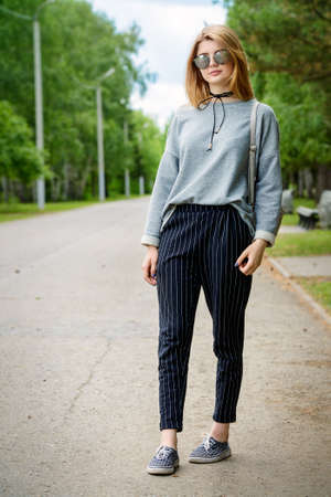 Teen style. Modern young girl with long blonde hair posing outdoor. Beauty, fashion.の写真素材