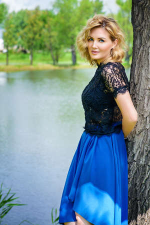 Beautiful middle aged woman having a rest at a park on a summer day. Mood of summer and carefree vacations. Beauty, cosmetics.の写真素材