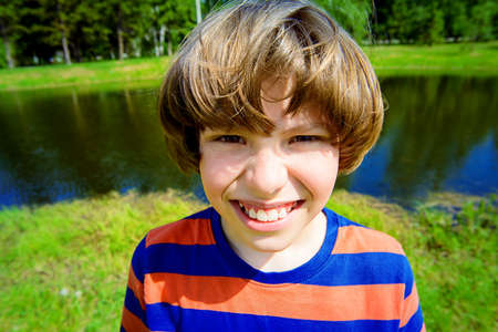 Cheerful boy on a sunny summer day. Happy childhood.の写真素材