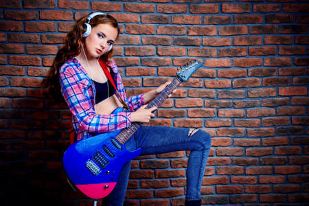 Portrait of an attractive girl with electric guitar. Rock music.の写真素材