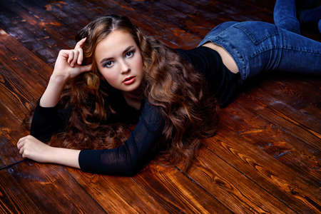 Beautiful girl with long curly hair. Beauty, fashion. Healthy hair, haircare cosmetics.の写真素材