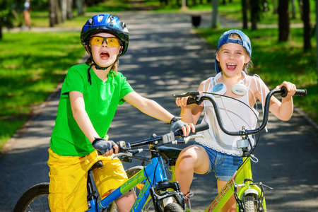 Two happy children riding their bikes. Happy summer holidays.の写真素材