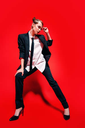 Full length portrait of an extravagant young woman posing in a man's suit.の写真素材