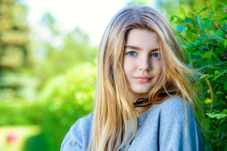 Portrait of a modern teen girl with long blonde hair posing outdoor. Beauty, fashion. Teen style.の写真素材