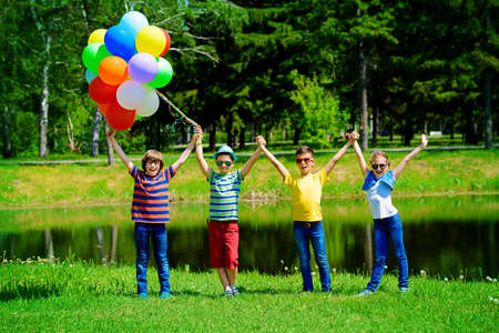 Group of cheerful children resting in the park. Outdoor activity. Summer holidays.の写真素材