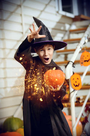 A boy in a costume of wizard with his magic wand is going to a halloween party. Trick or treat. Halloween concept.の写真素材