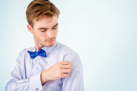 Men's beauty, fashion. Well-groomed young man wearing elegant suit and bow-tie.