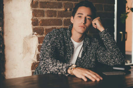 A young man spends time in a pub. Wine restaurant.の写真素材