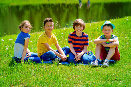 Group of cheerful children resting in the park. Outdoor activity. Summer holidays.の写真素材