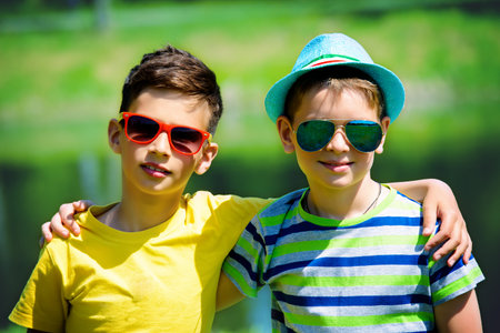 Portrait of two boys friends in the park on a sunny day. Summer holidays. Friendship.の写真素材