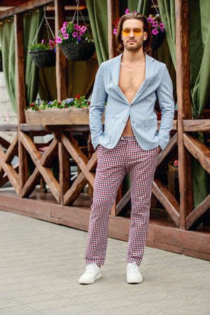 Happy young man in the city on a sunny summer day. Vacation. Male beauty, fashion.の写真素材