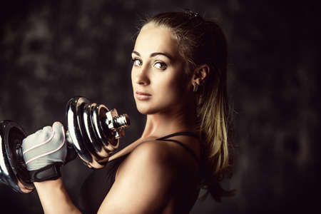 Beautiful athletic woman doing exercises with dumbbells. Fitness, bodybuilding. Health care.の写真素材