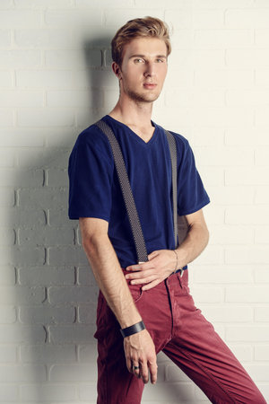 Men's beauty, fashion. Handsome male model posing at studio in casual clothes.