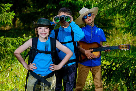 Three boys friends go hiking with backpacks. Summer holidays. Outdoor activities.の写真素材