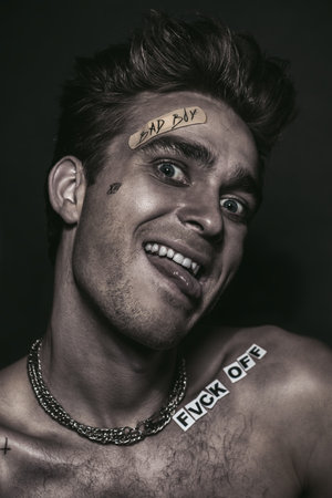 Bad boy concept. A portrait of a bad guy demonstrating antisocial behavior, rudeness and aggression....