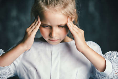 Cute girl is thinking about something with concentration.の写真素材