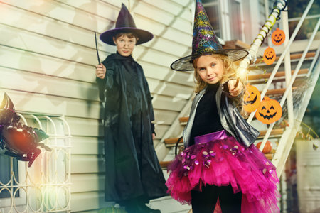 Happy children in a costumes of witches and wizards celebrating halloween. Trick or treat. Halloween party.の写真素材