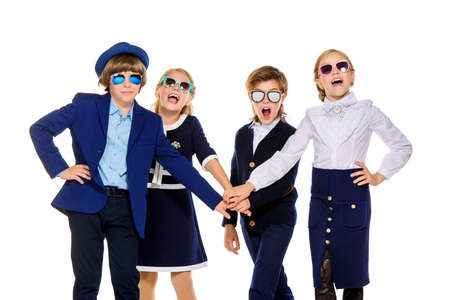 Group of modern children posing in school uniform and sunglasses. School fashion. Isolated over white background.の写真素材