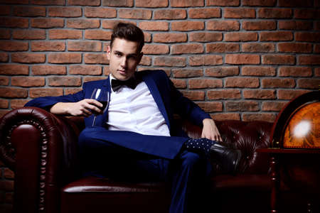 Imposing well dressed man in a luxurious apartments with classic interior. Luxury. Men's beauty, fashion.の写真素材