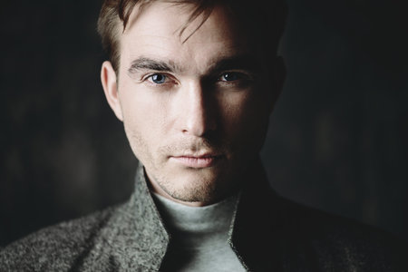 Male beauty, fashion. Portrait of a handsome man wearing coat. Seasonal clothes collection.の写真素材
