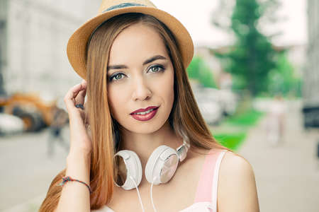 Happy smiling young woman on a sunny summer day. City street. Beauty, fashion.の写真素材