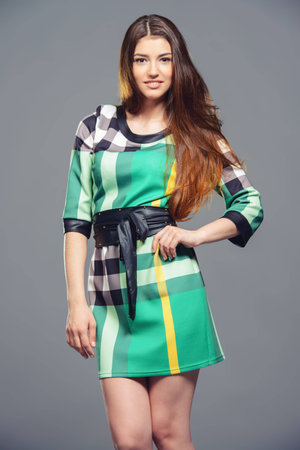 Fashion shot of a beautiful young woman with charming smile wearing summer dress. Studio shot.の写真素材